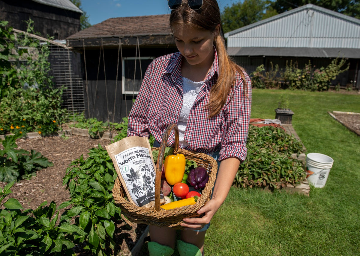 Young Woman holding an abundant basket of high quality produce grown with Jocelyn's Probiotics For Plants