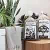 Bags of Worm Manure and Wood Chips sit beside a bathtub with plants in it