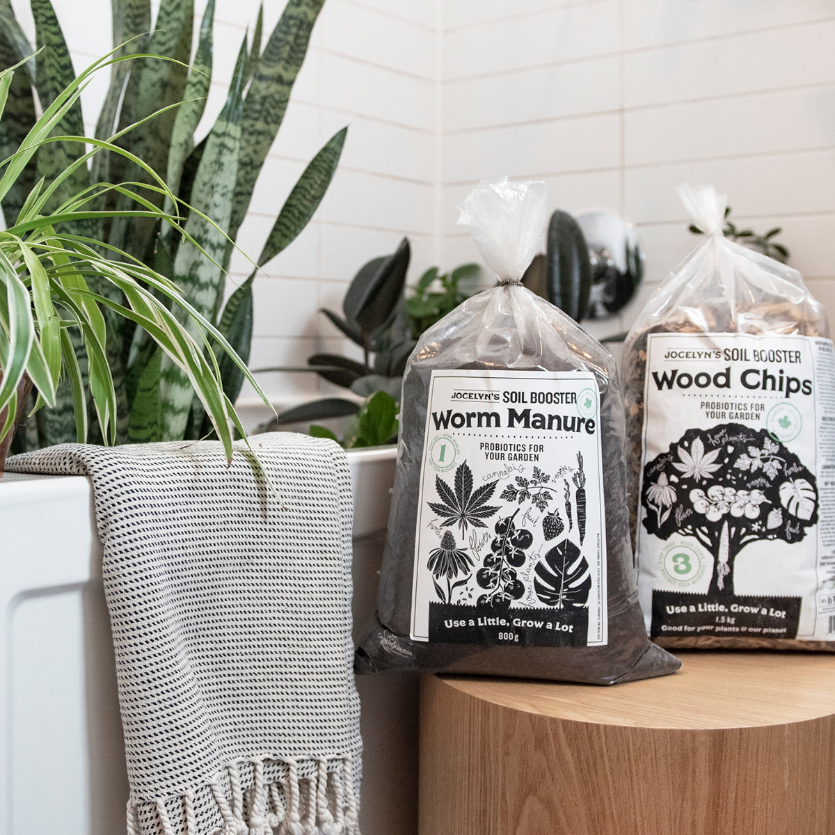 Bags of Worm Manure and Wood Chips sit beside a bathtub with plants in it